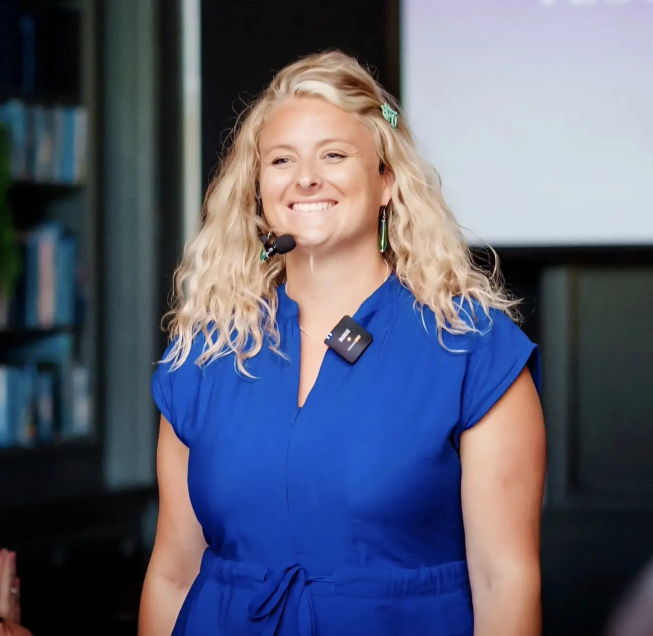 Jo Taylor smiling while speaking at an event, wearing a blue outfit